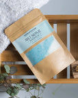 humbug epsom salt foot soak on bath rack with towel , leaves and nail brush