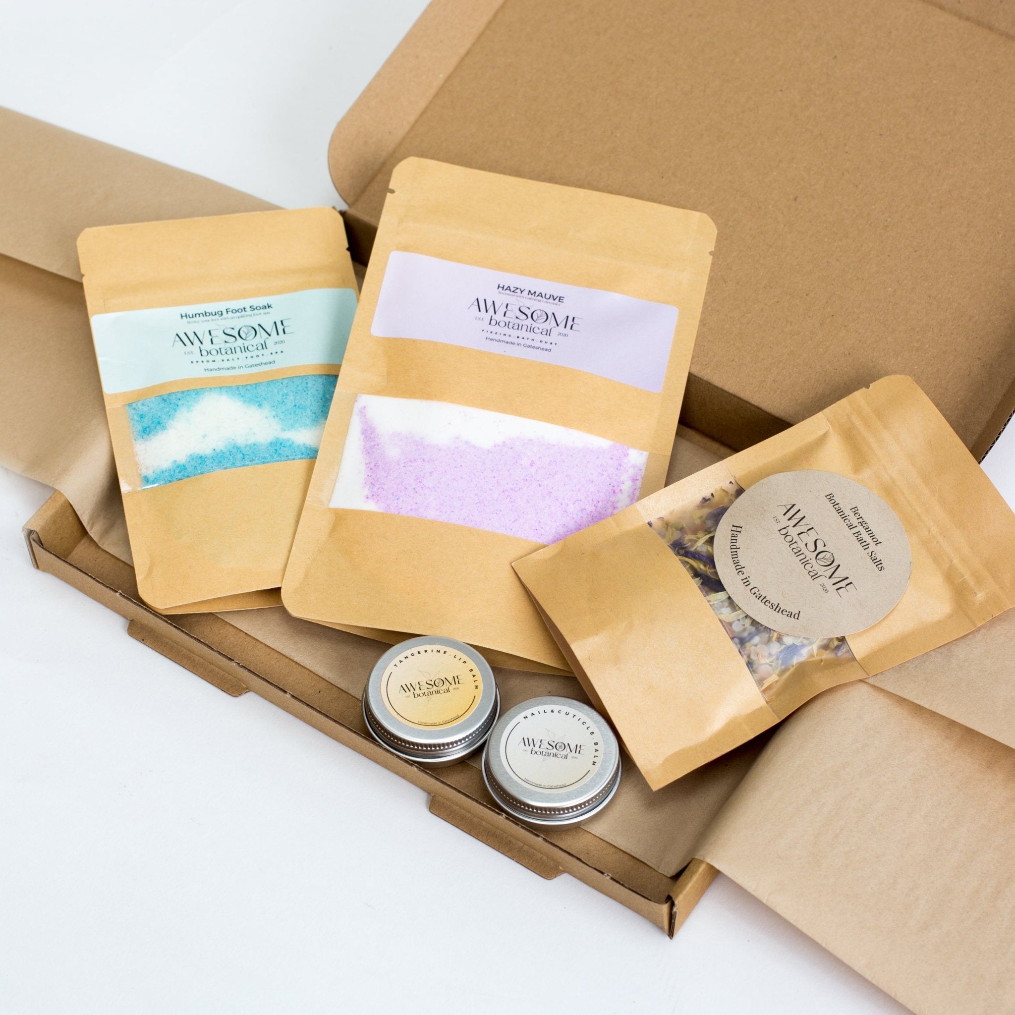 Spa Letterbox Gift Set, Contains Humbug Epsom Salt Foot Soak blue & White, Purple & white Hazy Mauve Fizzing Bath Dust, Bergamot Botanical Bath Salts, Nail & Cuticle Balm & Tangerine Lip Balm. 