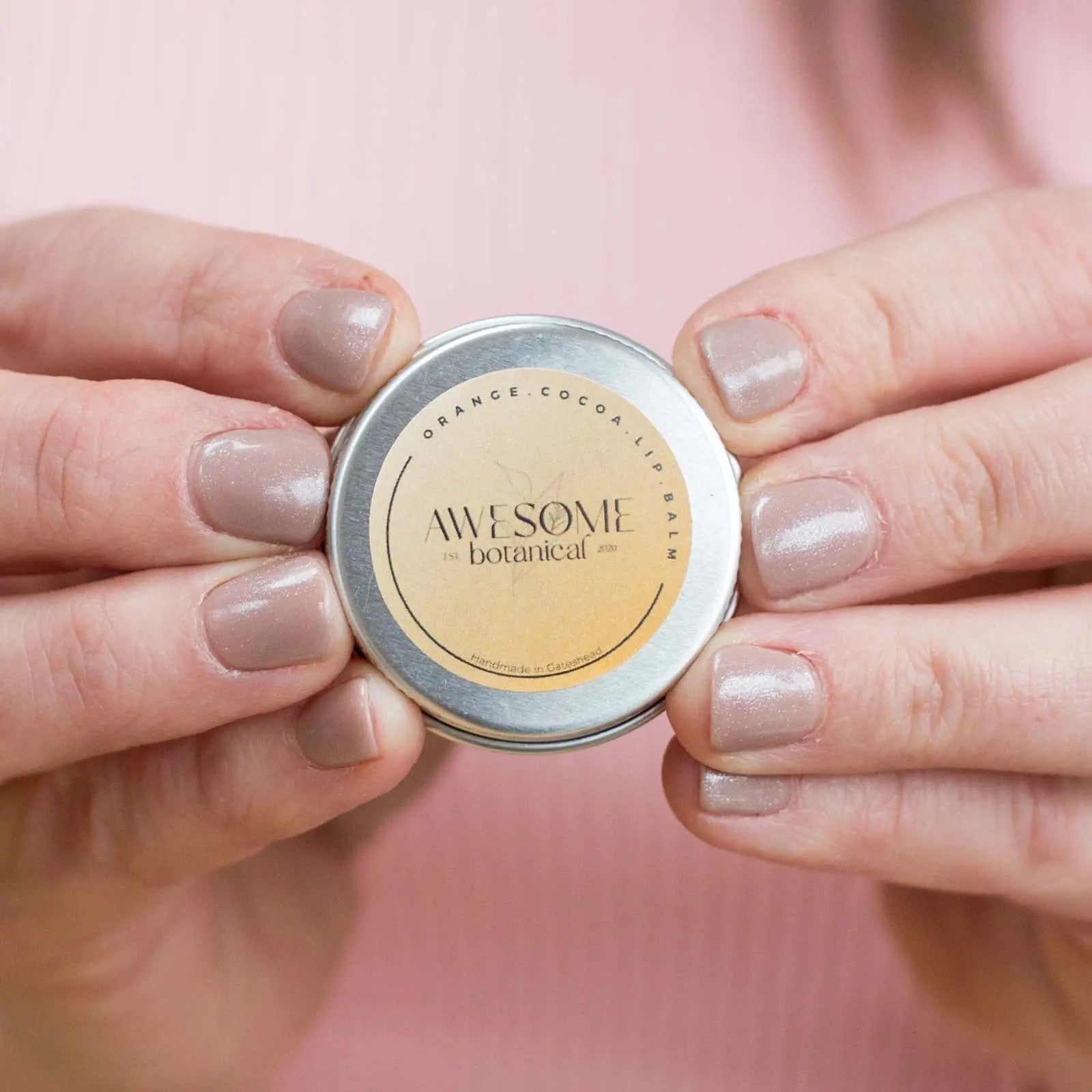Orange Cocoa Lip Balm in Girls Hands who is wearing a pink jumper