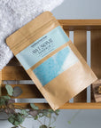 Humbug Epsom Salt Foot Soak on bath rack with towel, leaves and nail brush