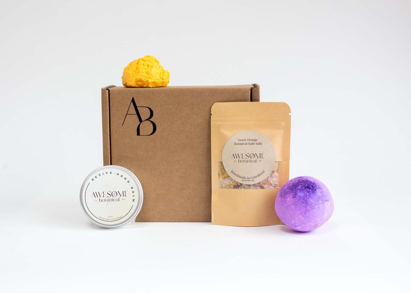 Awesome Botanical Monthly subscription box on white background with 4 products in front of the kraft box
